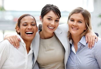 three-women-shoulder-to-shoulder-smiling
