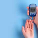 hands-hold-glucose-meter